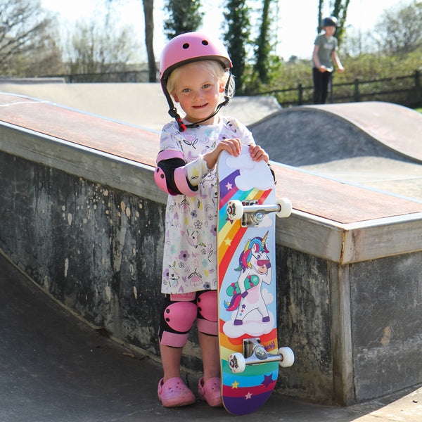 young girl at skatepark holding Venom junior skateboard