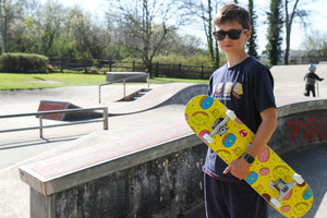 Preteen in skatepark holding Venom complete skateboard